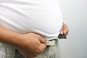 Man försöker knäppa byxorna