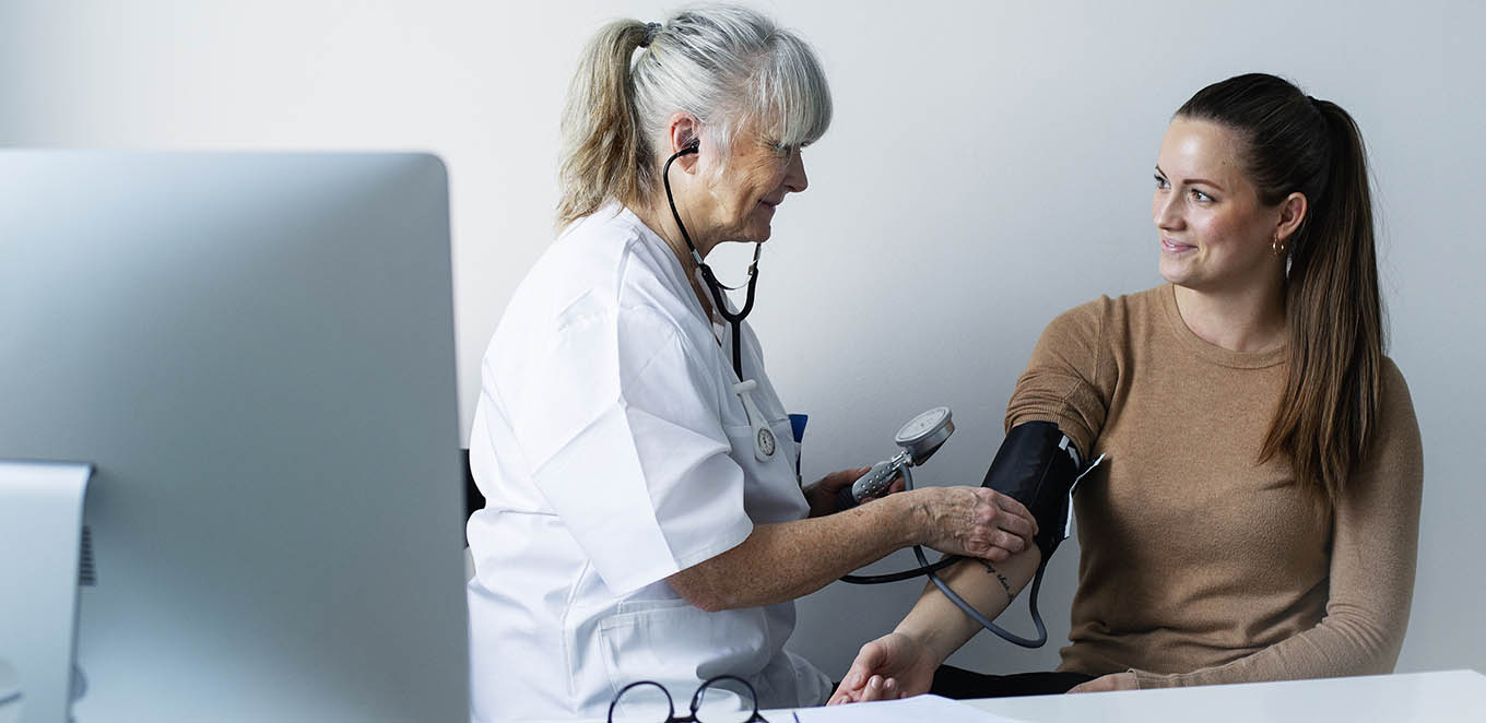 Vårdpersonal tar blodtryck på patient